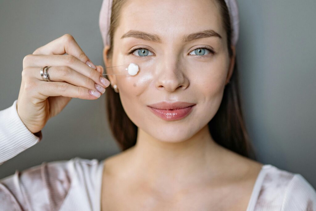 pexels-photo-7010954-7010954 Smiling woman applying facial cream for skincare routine